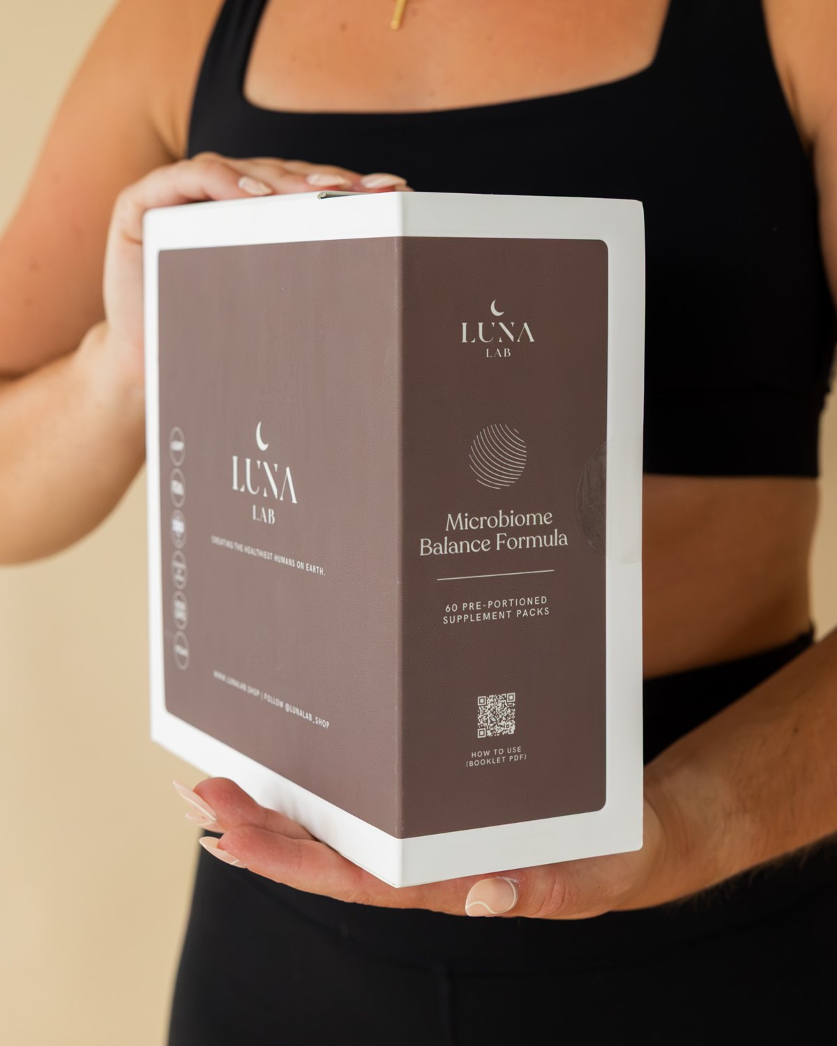 Woman holding the Microbiome Balance Formula box